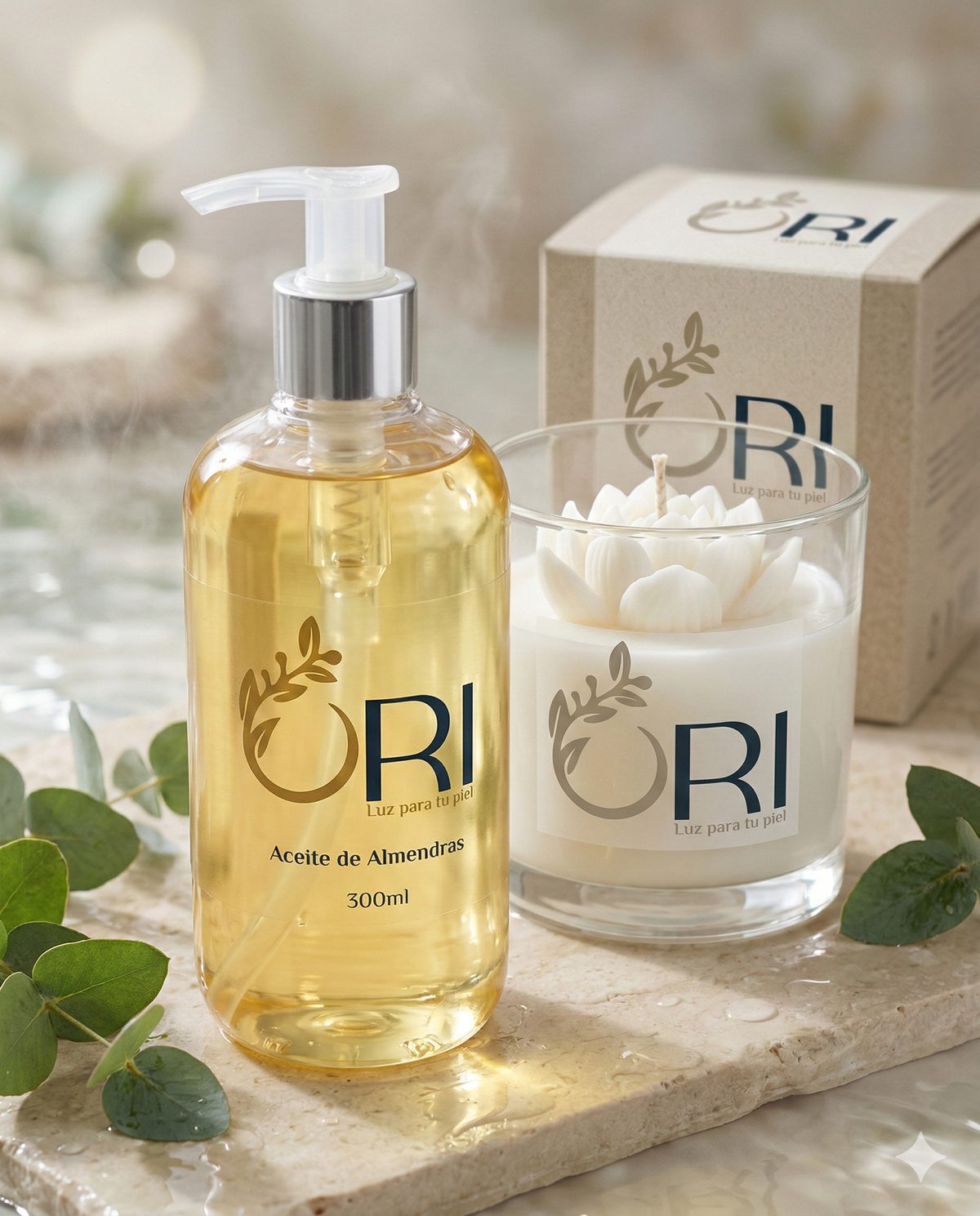 Kit de Bienestar: aceite de almendras y vela con flor de cera junto a su caja, sobre piedra clara con eucalipto